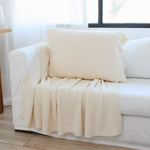 
                    
                      Funda de almohada Ginger color crema en sofá blanco junto a ventana-
                    
                  