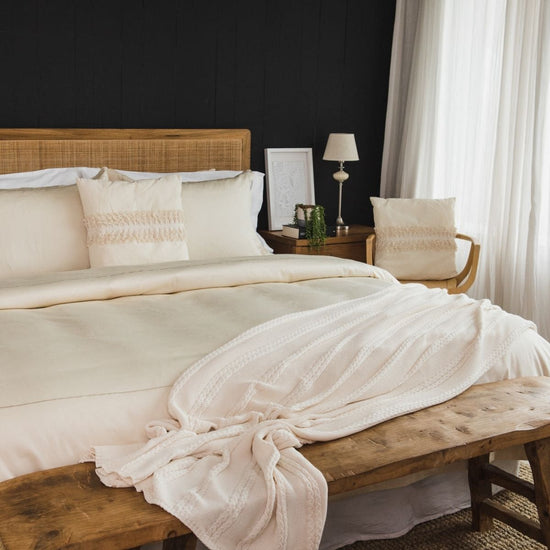 Cama elegante con funda de edredón crema y festón decorativo-