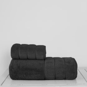 Set de toallas negras apiladas sobre superficie blanca-negro