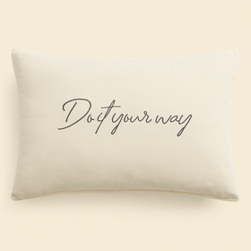 Almohada blanca con texto "Do it your way" en escritura cursiva-gris