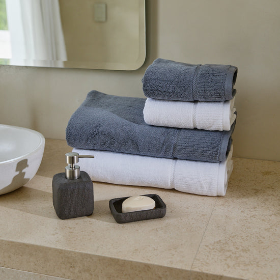 Set de toallas blancas y grises en cuarto de baño moderno-blanco