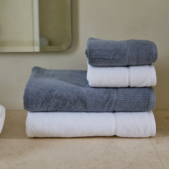 Set de toallas Supreme gris y blancas apiladas en baño-gris