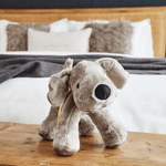 
                    
                      Peluche de perro gris y blanco suave sobre mesa de madera junto cama-gris
                    
                  