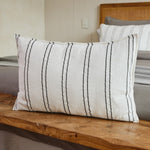 
                    
                      Almohada rectangular blanca con rayas grises sobre madera en dormitorio-
                    
                  