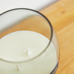 
                    
                      Vela blanca en taza de vidrio sobre superficie de madera-arrayán
                    
                  