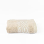 
                    
                      Toalla beige Viva con patrón geométrico blanco enrollada-beige
                    
                  